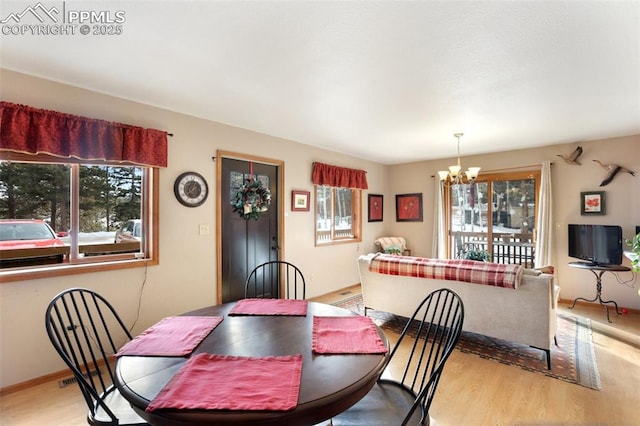 dining area with an inviting chandelier, plenty of natural light, and light hardwood / wood-style floors