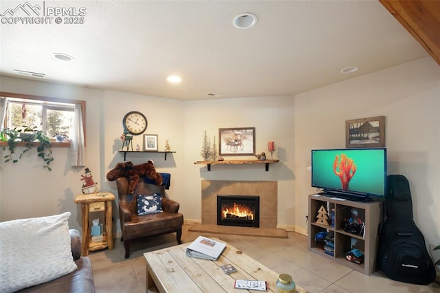 living room with a fireplace and light tile patterned floors