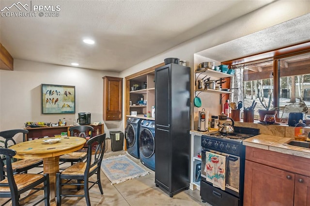 kitchen with separate washer and dryer, tile counters, and black range with gas cooktop