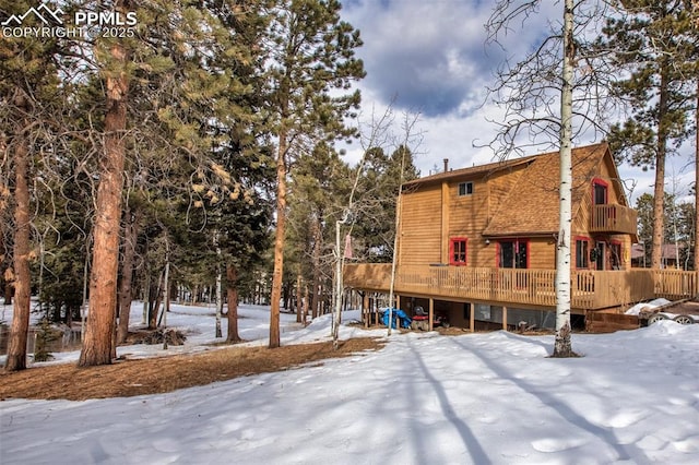 snow covered house featuring a deck