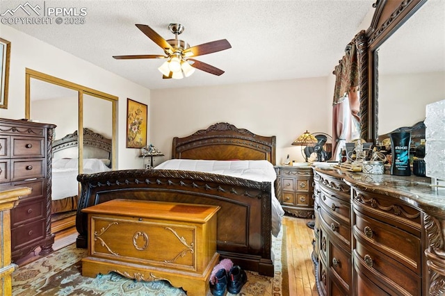 bedroom with a closet, ceiling fan, a textured ceiling, and light wood-type flooring