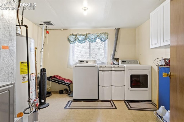 laundry area featuring washing machine and dryer, cabinets, and water heater