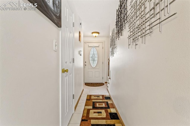 doorway to outside with light tile patterned flooring