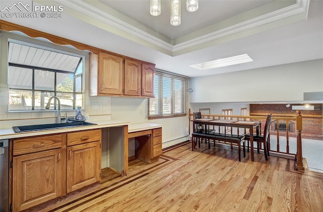 kitchen featuring sink, baseboard heating, a tray ceiling, decorative backsplash, and light wood-type flooring