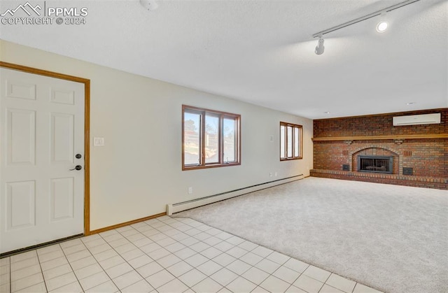 unfurnished living room with light carpet, track lighting, a brick fireplace, a wall mounted AC, and a baseboard heating unit