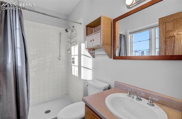 bathroom featuring a shower with shower curtain, vanity, and toilet