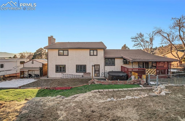 rear view of house with a hot tub