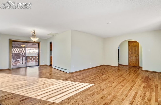 spare room featuring light hardwood / wood-style floors and a baseboard radiator