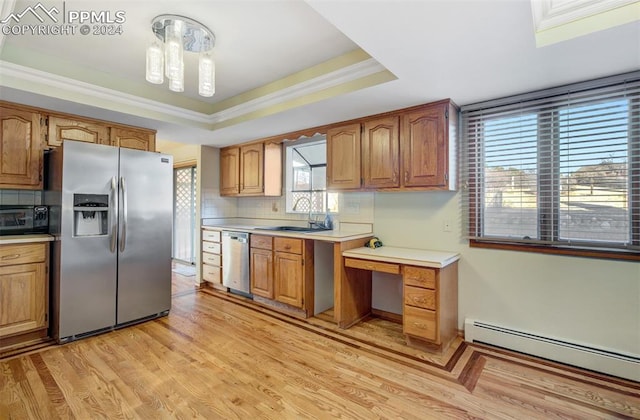 kitchen with sink, a healthy amount of sunlight, baseboard heating, a raised ceiling, and appliances with stainless steel finishes