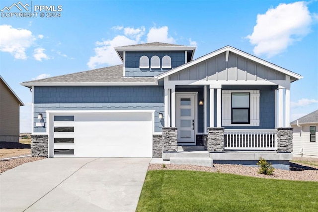 view of front of property with covered porch, a front yard, and a garage