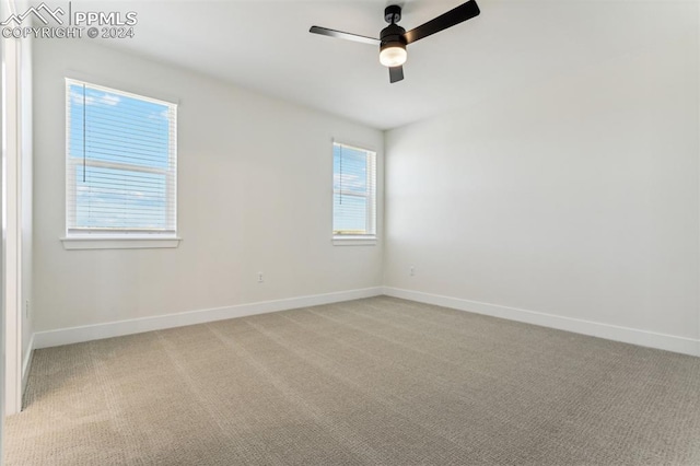 empty room with ceiling fan and light carpet