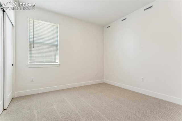 unfurnished room featuring light carpet