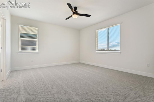 spare room with ceiling fan and light carpet