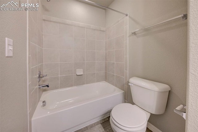 bathroom featuring tiled shower / bath combo and toilet