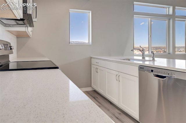 kitchen featuring dishwasher, stove, white cabinets, sink, and light hardwood / wood-style flooring