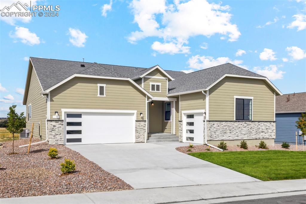 craftsman-style house with a front lawn, a garage, and central AC unit