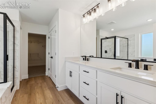 bathroom featuring hardwood / wood-style flooring, vanity, and a shower with shower door