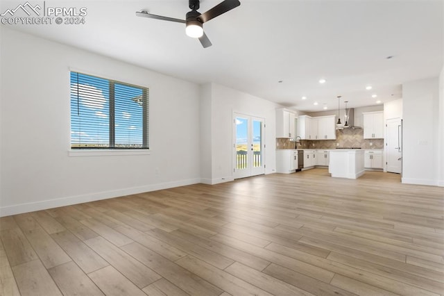 unfurnished living room with ceiling fan, light hardwood / wood-style flooring, and a healthy amount of sunlight