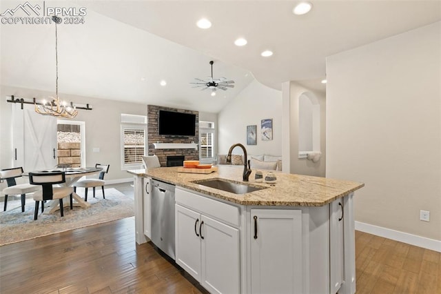 kitchen featuring white cabinetry, dishwasher, sink, decorative light fixtures, and a kitchen island with sink