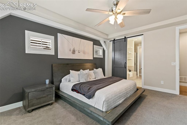 carpeted bedroom featuring a barn door, ceiling fan, and connected bathroom