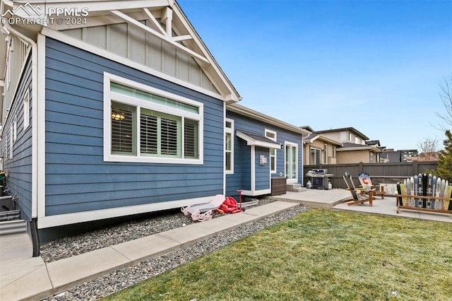 back of house with a lawn and a patio area