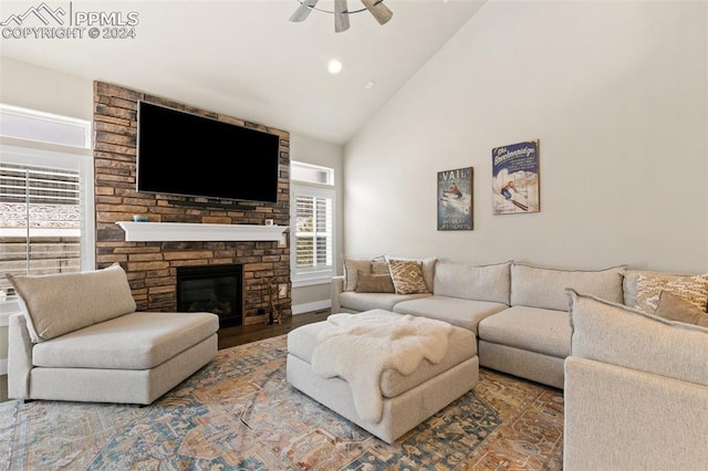 living room featuring a fireplace, hardwood / wood-style floors, high vaulted ceiling, and ceiling fan