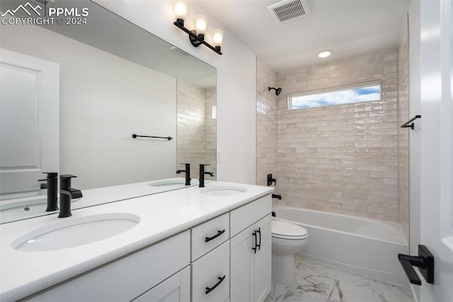 full bathroom featuring vanity, tiled shower / bath combo, and toilet