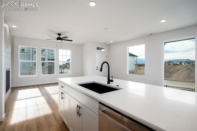 kitchen featuring ceiling fan, sink, light hardwood / wood-style flooring, dishwasher, and white cabinetry