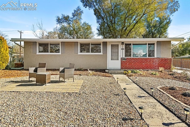 ranch-style house with a patio and an outdoor hangout area