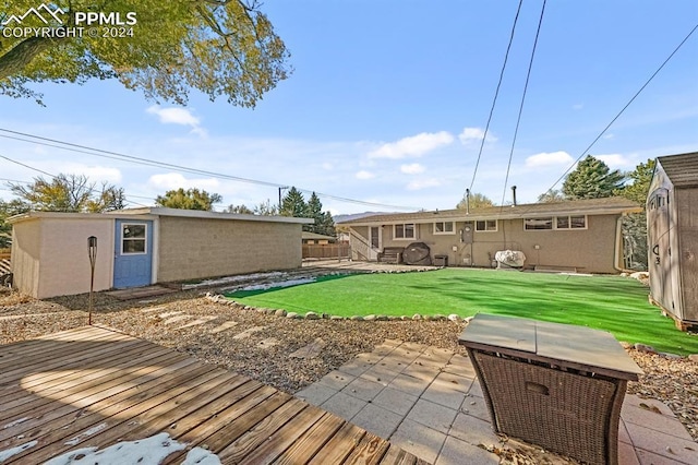 back of house featuring a storage unit and a lawn