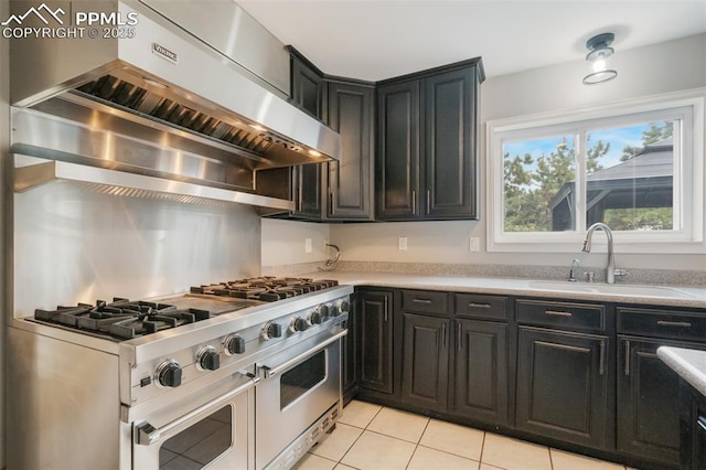 kitchen featuring light tile patterned flooring, stainless steel stove, range hood, and sink