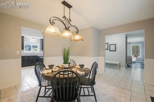 tiled dining area featuring a chandelier and sink