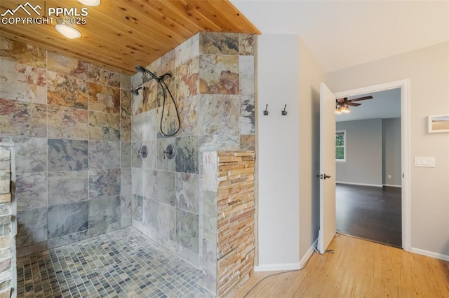 bathroom with tiled shower, hardwood / wood-style floors, ceiling fan, and wooden ceiling