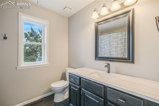 bathroom featuring tile patterned floors, vanity, toilet, and a wealth of natural light