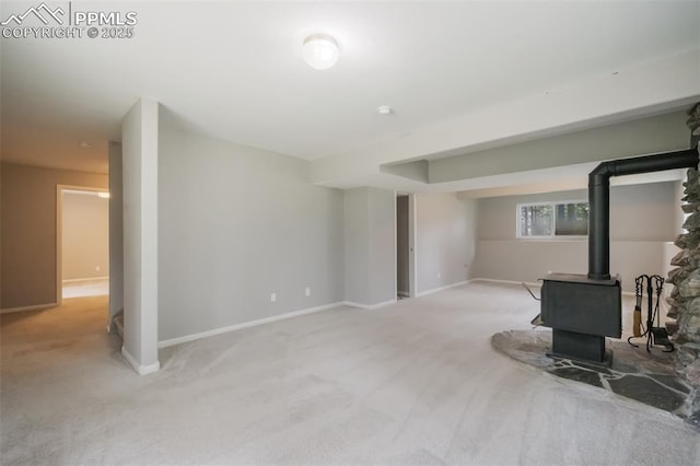 living room with a wood stove and light carpet