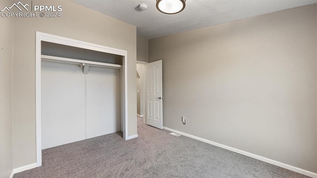 unfurnished bedroom with carpet flooring and a closet