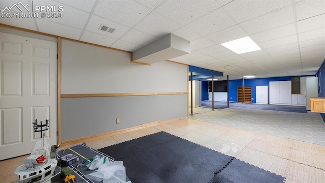 workout room with a paneled ceiling