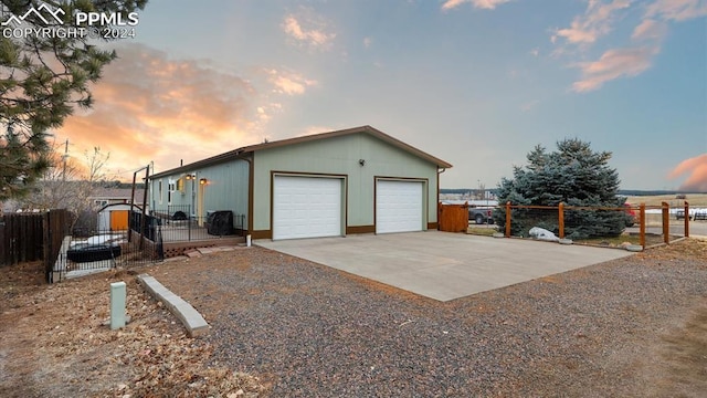 view of garage at dusk