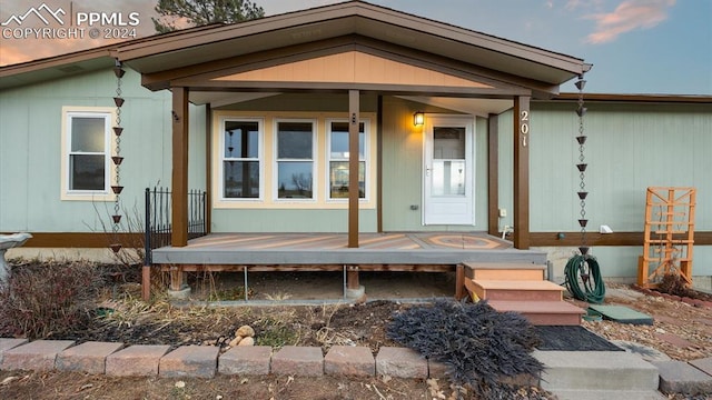 exterior entry at dusk featuring covered porch