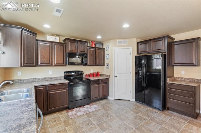 kitchen featuring dark brown cabinetry, sink, and black appliances