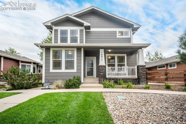 craftsman house featuring covered porch and a front yard