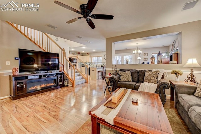 living room featuring hardwood / wood-style floors and ceiling fan with notable chandelier