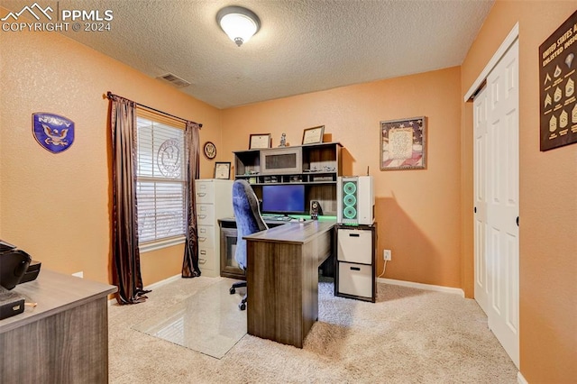 carpeted home office with a textured ceiling