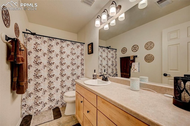 bathroom with tile patterned floors, vanity, toilet, and walk in shower