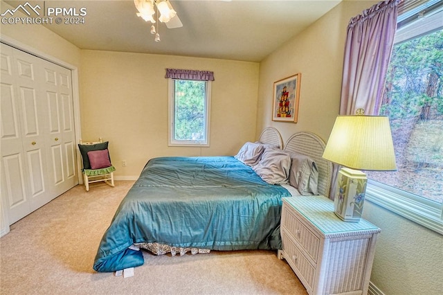 carpeted bedroom with ceiling fan and a closet