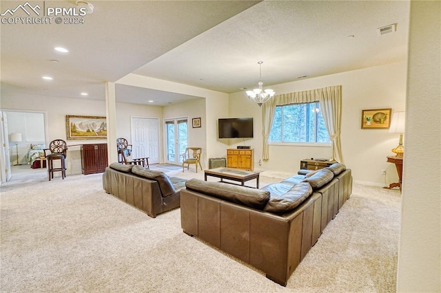 living room with light carpet and a chandelier