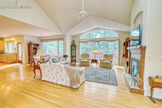 living room featuring ceiling fan, high vaulted ceiling, and light hardwood / wood-style floors