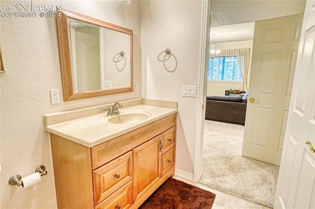 bathroom featuring tile patterned flooring, vanity, and a notable chandelier