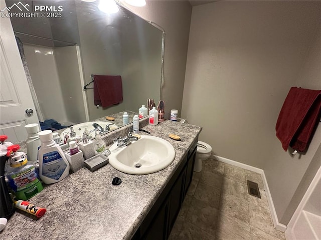 bathroom with toilet, vanity, and a shower