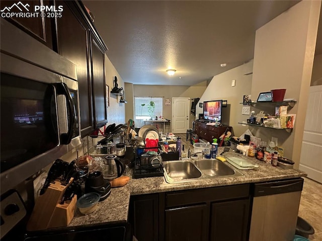 kitchen featuring appliances with stainless steel finishes, sink, dark brown cabinetry, and a textured ceiling